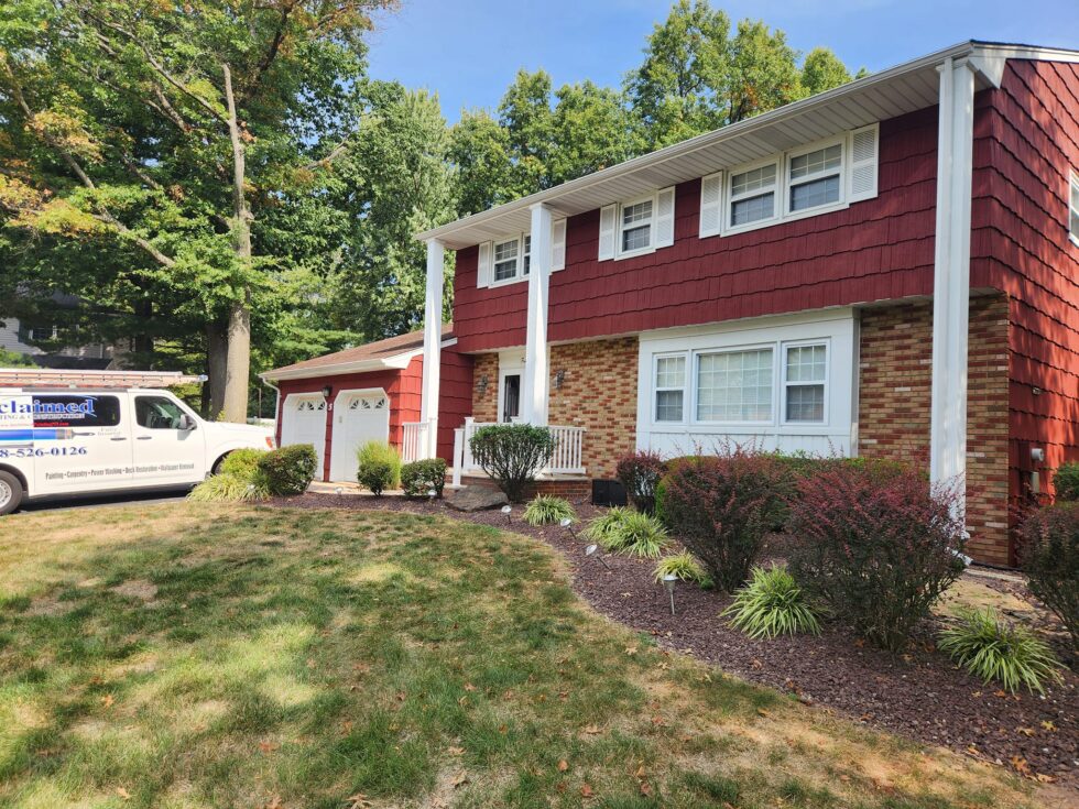 Completed exterior painting project by Acclaimed Painting & Construction, New Jersey A freshly painted red-and-white New Jersey home exterior with the Acclaimed Painting & Construction van on site